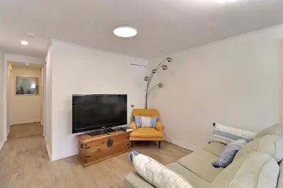 a living room with a couch and a flat screen tv at Private Peaceful Queen Room Free Parking in Saint-Bruno-de-Montarville