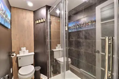 a bathroom with a toilet and a glass shower at Private Peaceful Queen Room Free Parking in Saint-Bruno-de-Montarville