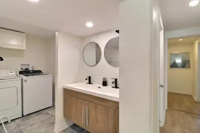 a white bathroom with a sink and a washing machine at Private Peaceful Queen Room Free Parking in Saint-Bruno-de-Montarville