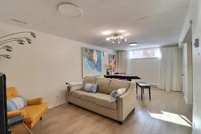 a living room with a couch and a table at Private Peaceful Queen Room Free Parking in Saint-Bruno-de-Montarville