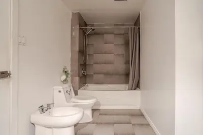 a bathroom with two toilets and a tub and a sink at Majestic Villa in Downtown Griffintown in Montréal