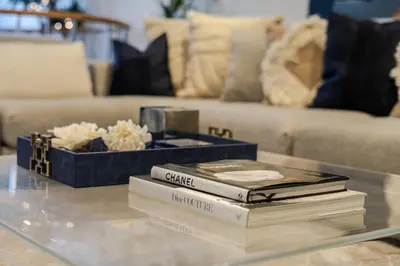 a stack of books on a glass table with a couch at Majestic Villa in Downtown Griffintown in Montréal