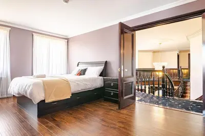 a bedroom with a large bed and a mirror at Waterfront Mansion with Mont-Saint-Hilaire Views, Near Montreal in Beloeil Village