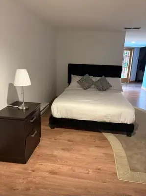 a bedroom with a bed and a table with a lamp at Waterfront Mansion with Mont-Saint-Hilaire Views, Near Montreal in Beloeil Village