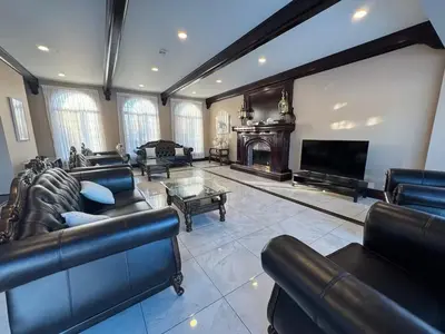 a large living room with leather furniture and a fireplace at Waterfront Mansion with Mont-Saint-Hilaire Views, Near Montreal in Beloeil Village