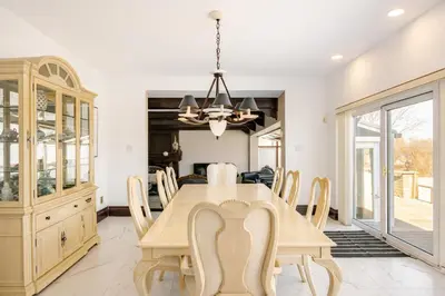 a dining room with a wooden table and chairs at Waterfront Mansion with Mont-Saint-Hilaire Views, Near Montreal in Beloeil Village