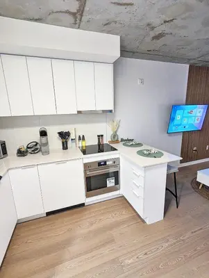 a kitchen with white cabinets and a stove at Studio Chic - Centre MTL in Montréal