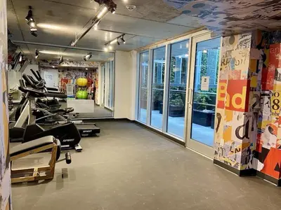 a room with a gym with tread machines and windows at Studio Chic - Centre MTL in Montréal