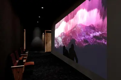 a large screen in a room with a group of chairs at SonoLux in Montréal