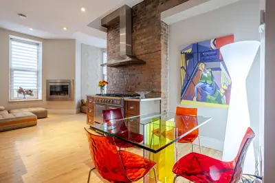 a kitchen with a glass table and red chairs at Downtown Retreat with Modern Comfort in Montréal