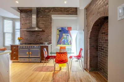 a kitchen with a glass table and red chairs at Downtown Retreat with Modern Comfort in Montréal