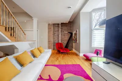 a living room with a white couch and a red chair at Downtown Retreat with Modern Comfort in Montréal
