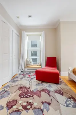a red chair and a rug in a room with a window at Downtown Retreat with Modern Comfort in Montréal