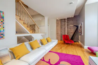 a living room with a white couch and a red chair at Downtown Retreat with Modern Comfort in Montréal