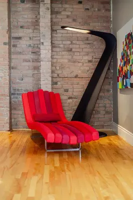 a red chair in a room with a brick wall at Downtown Retreat with Modern Comfort in Montréal