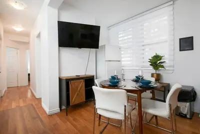 a dining room with a table and chairs and a television at Exclusive Loft Living in the Heart of Montreal in Montréal