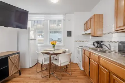 a kitchen with a small table with chairs and a sink at Exclusive Loft Living in the Heart of Montreal in Montréal