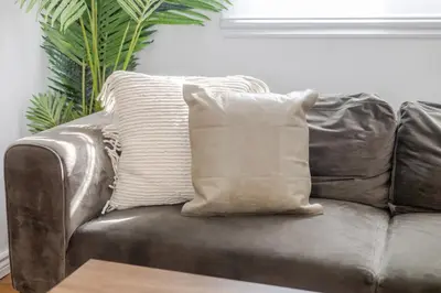 a brown leather couch with two pillows on it at Exclusive Loft Living in the Heart of Montreal in Montréal