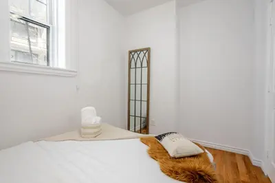 a bedroom with a bed with a pillow and a window at Exclusive Loft Living in the Heart of Montreal in Montréal
