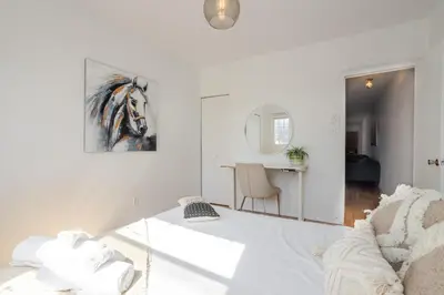 a white room with a bed and a table at Bright 2BR in Plateau Mont Royal Downtown in Montréal