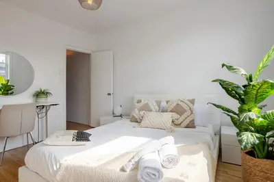 a bedroom with a white bed and a plant at Bright 2BR in Plateau Mont Royal Downtown in Montréal