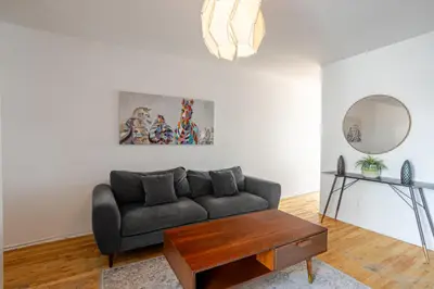a living room with a couch and a mirror at Bright 2BR in Plateau Mont Royal Downtown in Montréal