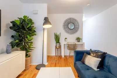 a living room with a blue couch and a mirror at Stunning 2B in Plateau Mont-Royal in Montréal