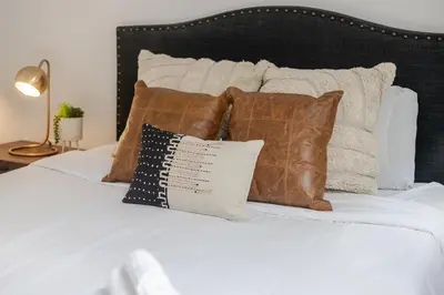 a bed with brown and white pillows on it at Stunning 2B in Plateau Mont-Royal in Montréal