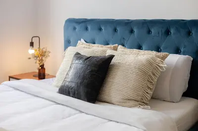 a bed with a blue headboard and pillows on it at Stunning 2B in Plateau Mont-Royal in Montréal