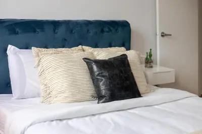 a bed with black and white pillows on it at Stunning 2B in Plateau Mont-Royal in Montréal