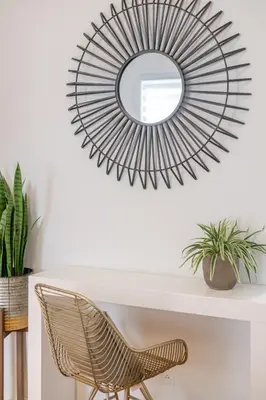 a mirror above a white table with a rattan chair at Stunning 2B in Plateau Mont-Royal in Montréal