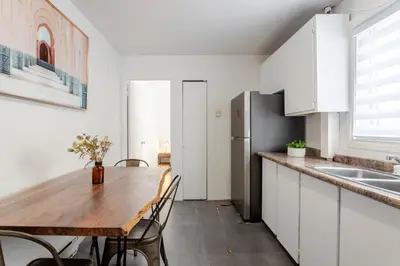 a kitchen with a wooden table and a refrigerator at Stunning 2B in Plateau Mont-Royal in Montréal