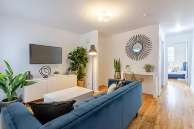 a living room with a blue couch and a tv at Stunning 2B in Plateau Mont-Royal in Montréal