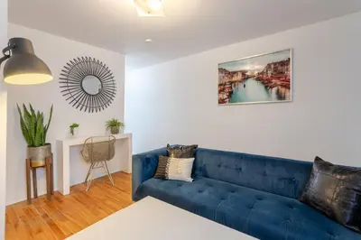 a living room with a blue couch and a mirror at Stunning 2B in Plateau Mont-Royal in Montréal