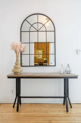 a console table with a large mirror on it at Convenient 4BR in Mont Royal Downtown in Montréal