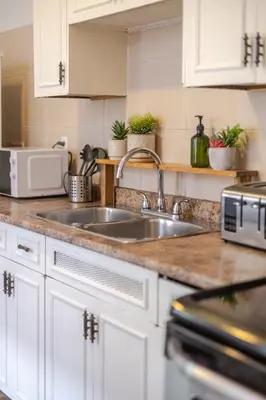a kitchen with white cabinets and a sink at Convenient 4BR in Mont Royal Downtown in Montréal