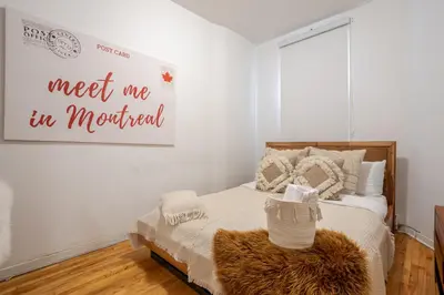 a bedroom with a bed with a sign that reads meet me in montreal at Convenient 4BR in Mont Royal Downtown in Montréal