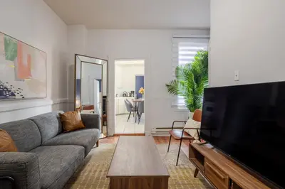 a living room with a couch and a flat screen tv at Ideal 4BR Property in Downtown Montreal in Montréal