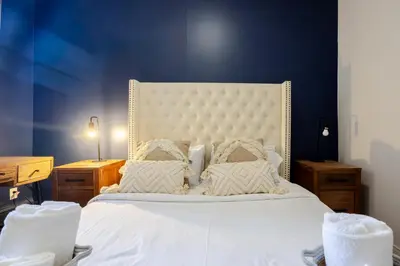 a bedroom with a white bed with a blue wall at Ideal 4BR Property in Downtown Montreal in Montréal
