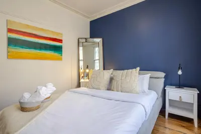 a bedroom with a large white bed with blue walls at Ideal 4BR Property in Downtown Montreal in Montréal
