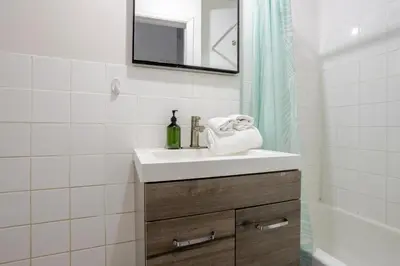 a white bathroom with a sink and a mirror at Ideal 4BR Property in Downtown Montreal in Montréal