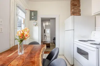 a kitchen with a wooden table with a vase of flowers at Ideal 4BR Property in Downtown Montreal in Montréal