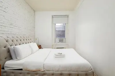 a white bedroom with a large bed and a window at Beautiful apartment in Downtown in Montréal