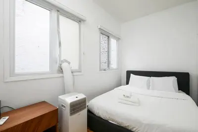a bedroom with a bed with a radiator and two windows at Beautiful apartment in Downtown in Montréal