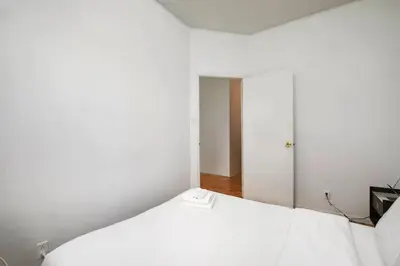 a white bed in a white room with a window at Beautiful apartment in Downtown in Montréal