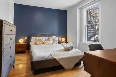 a bedroom with a bed with a blue accent wall at Magnificent 4BR in Downtown Mont-Royal in Montréal