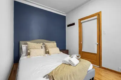 a blue bedroom with a bed with towels on it at Magnificent 4BR in Downtown Mont-Royal in Montréal