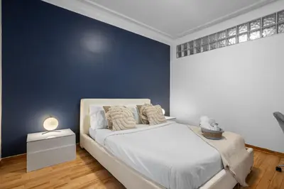 a bedroom with a white bed and a blue wall at Magnificent 4BR in Downtown Mont-Royal in Montréal