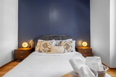a bedroom with a large bed with a blue wall at Magnificent 4BR in Downtown Mont-Royal in Montréal