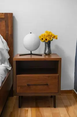 a nightstand with a vase of flowers and a lamp on it at Magnificent 4BR in Downtown Mont-Royal in Montréal